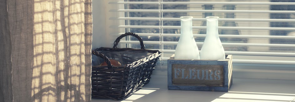 Horizontal blinds behind glass bottles